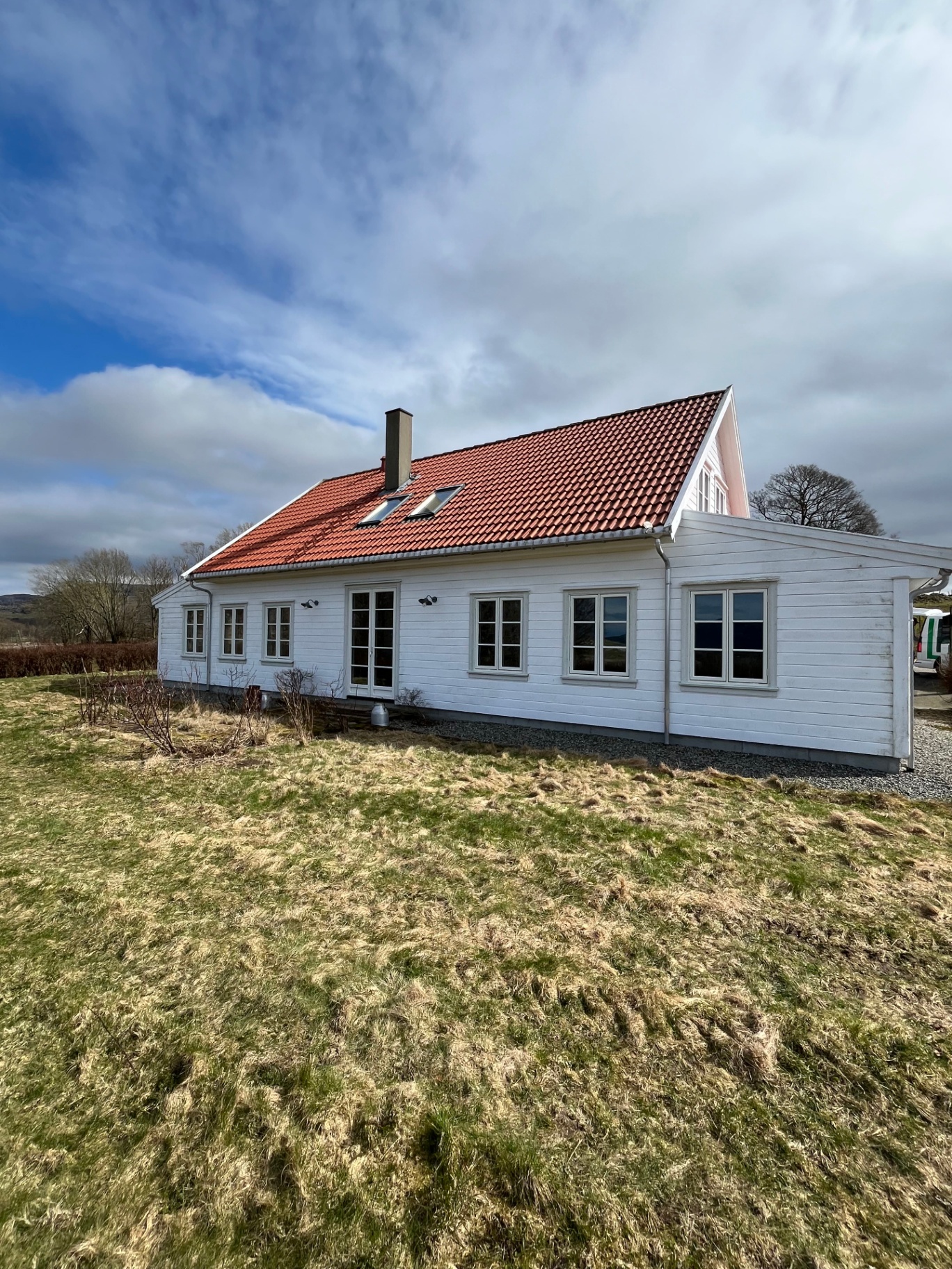 Rehabilitert hvit trehus-bolig med rødt teglstein-tak i Sandnes, ferdigstilt av Danielsen Bygg AS